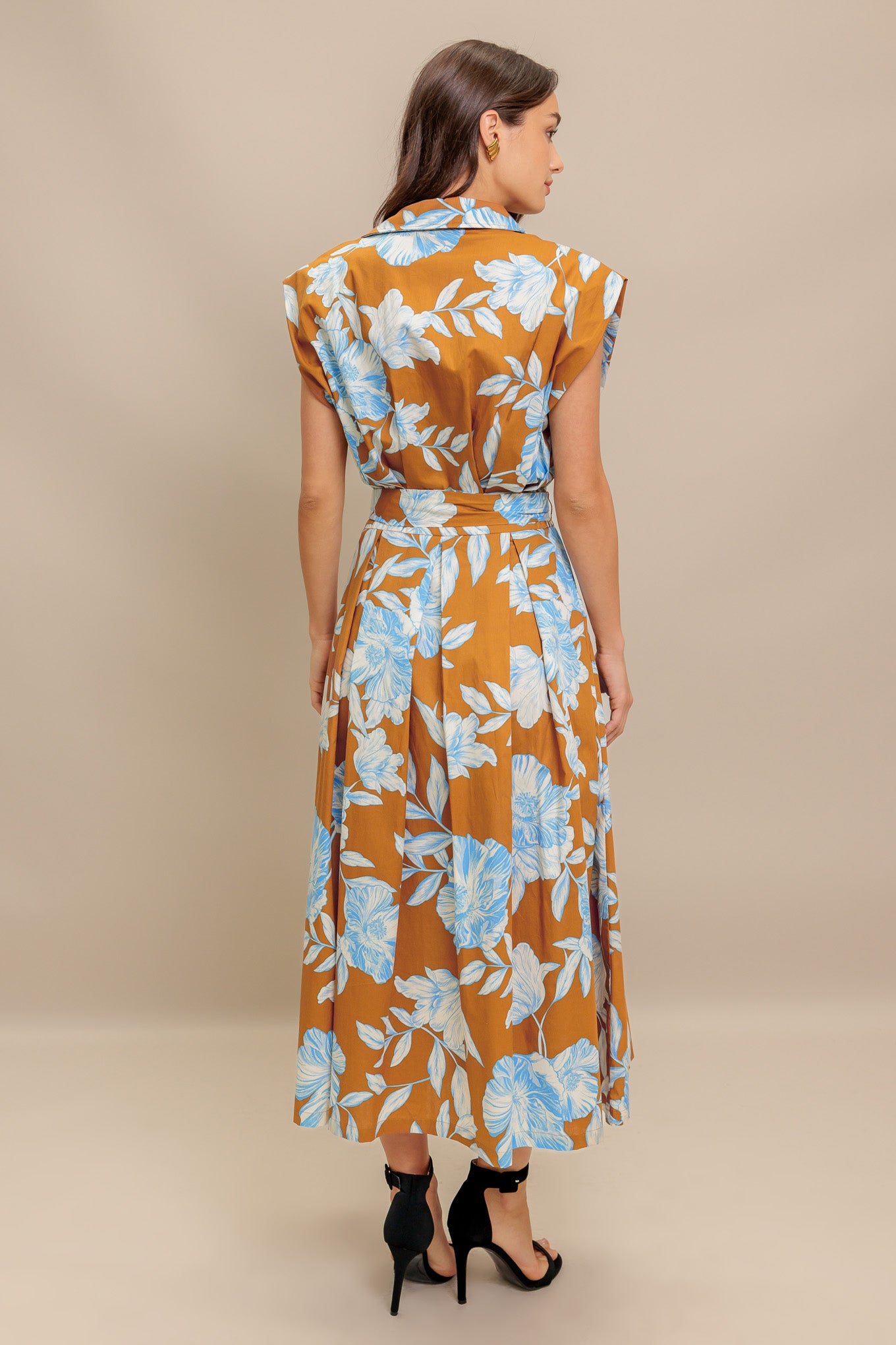 A printed woven midi dress featuring collar, short sleeve, front button down, self sash tie and full skirt