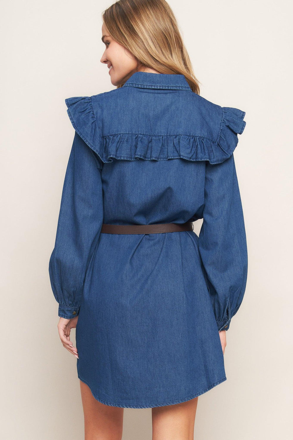 A denim mini dress featuring collar, square yoke with ruffles, long sleeve, front button down and contrasting belt
