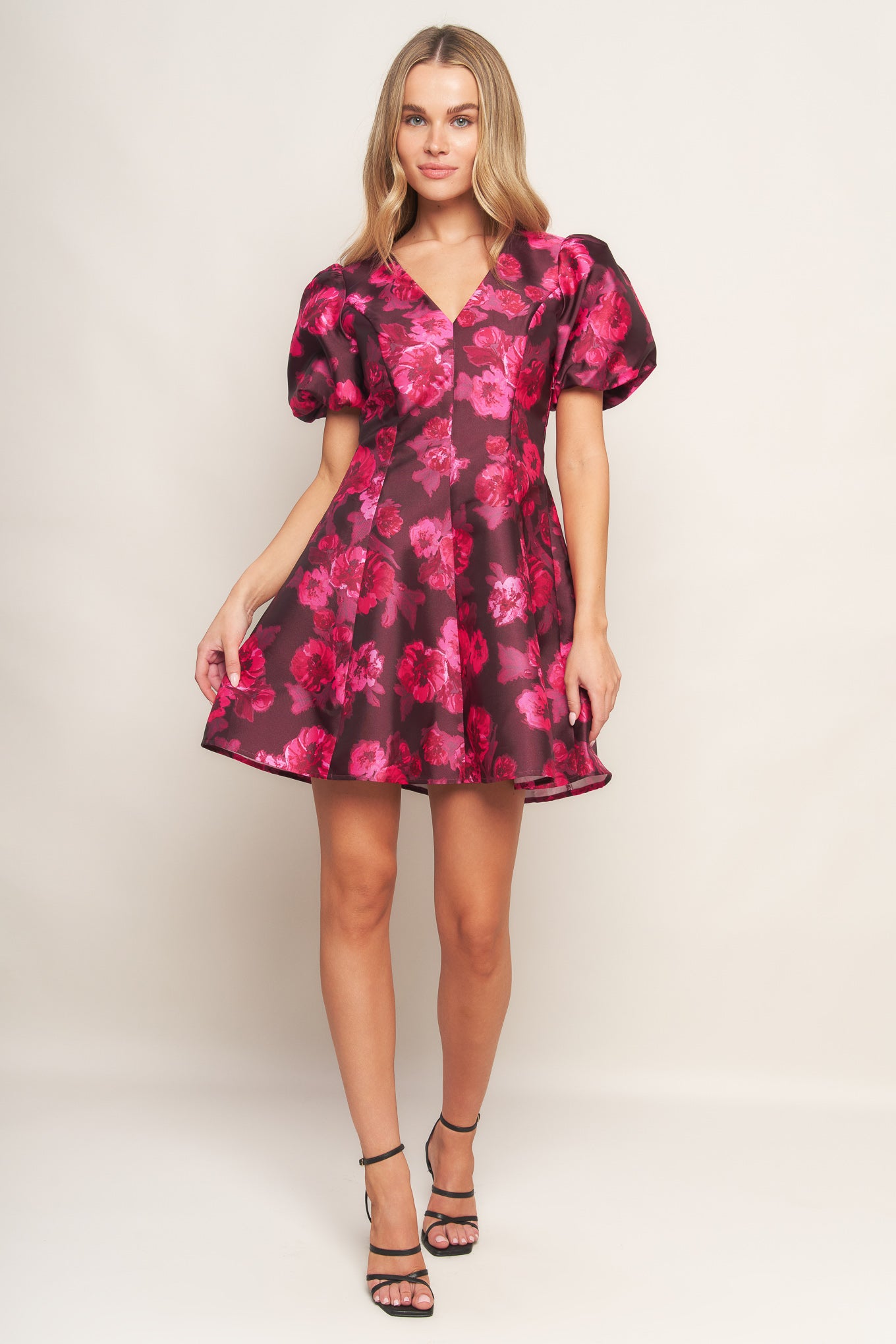 A printed woven mini dress featuring V neckline, short puff sleeve, circle skirt and back zipper closure