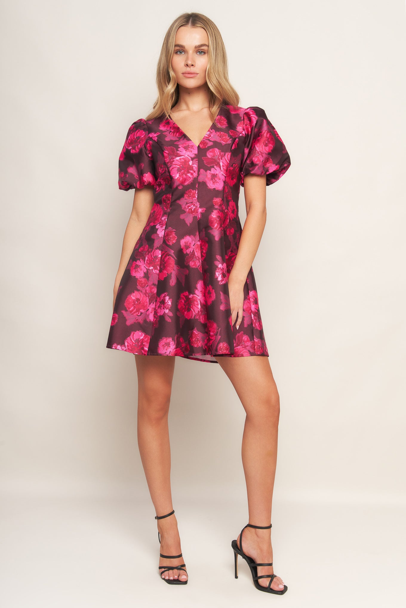 A printed woven mini dress featuring V neckline, short puff sleeve, circle skirt and back zipper closure