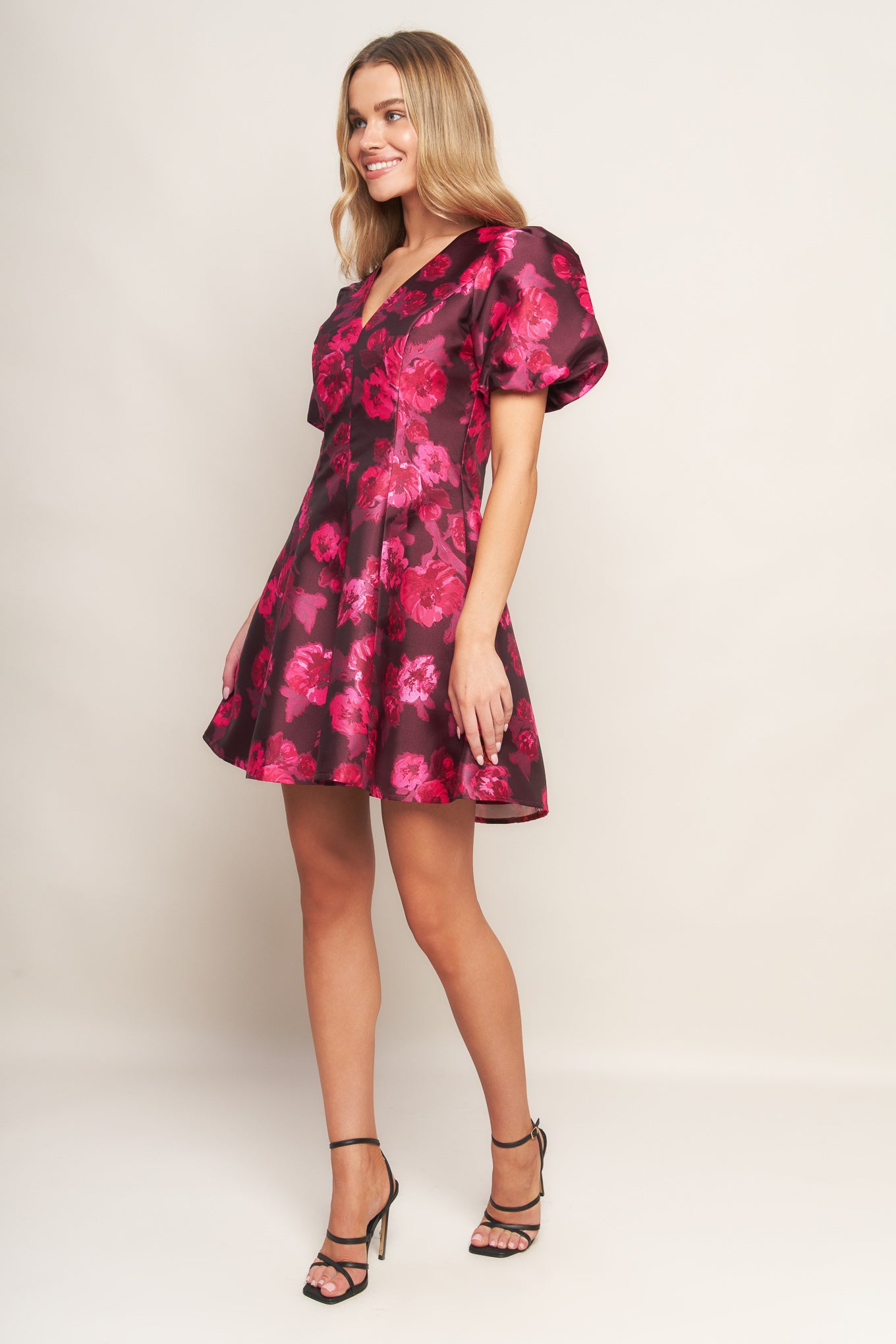 A printed woven mini dress featuring V neckline, short puff sleeve, circle skirt and back zipper closure