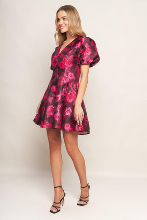 A printed woven mini dress featuring V neckline, short puff sleeve, circle skirt and back zipper closure