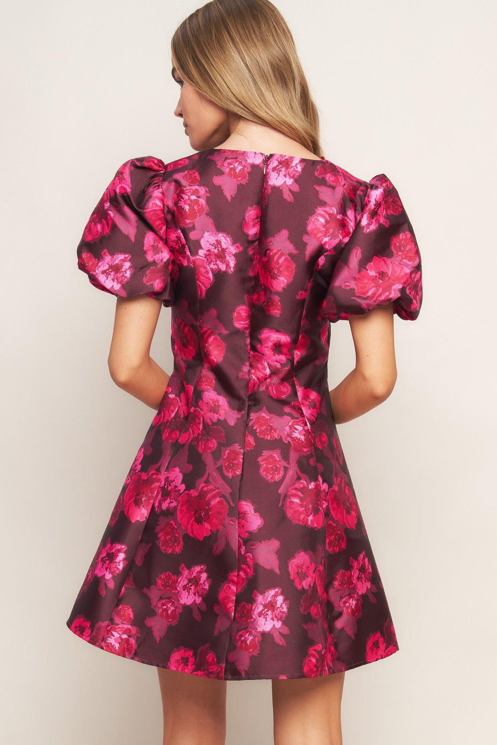 A printed woven mini dress featuring V neckline, short puff sleeve, circle skirt and back zipper closure