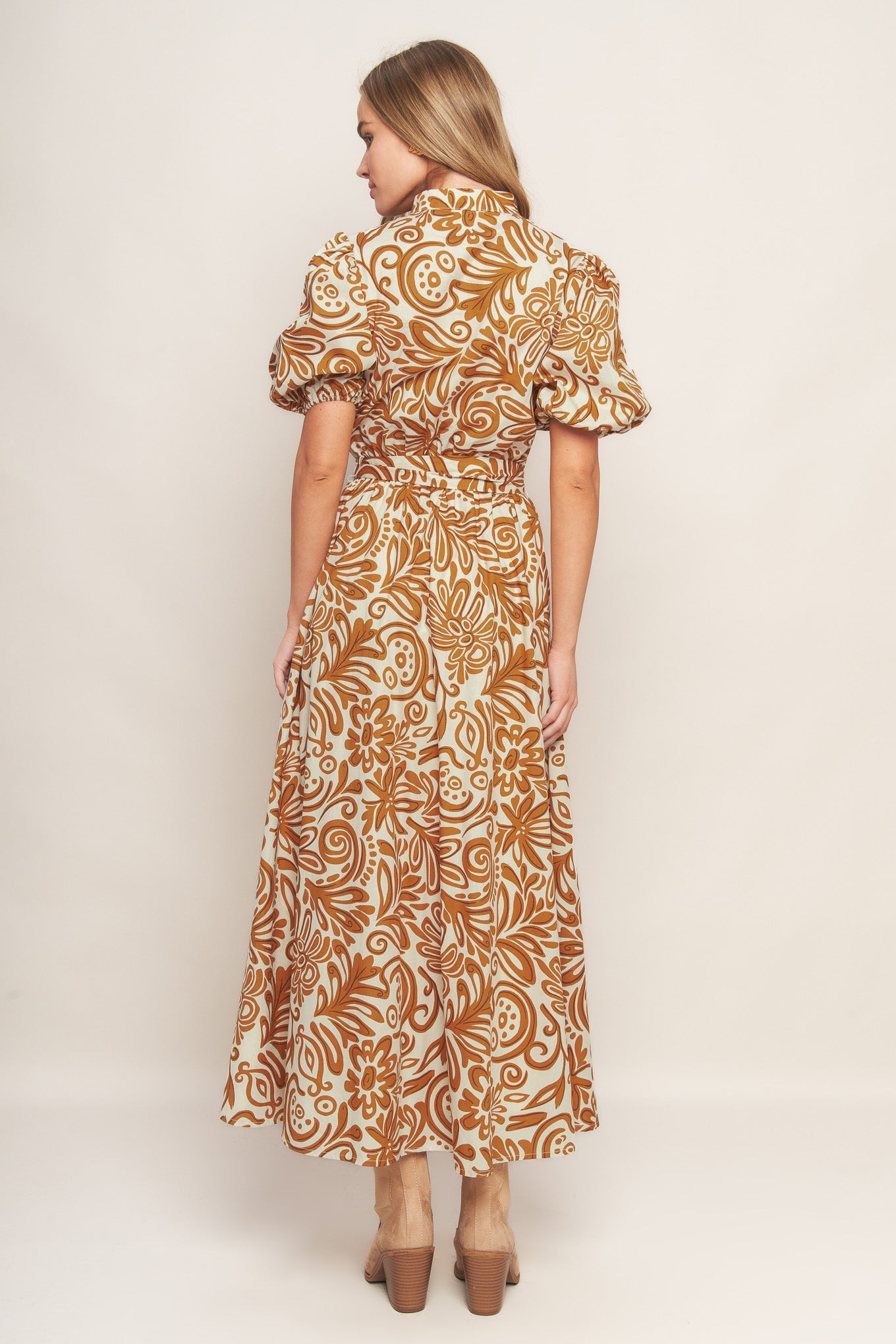 A printed woven midi dress featuring high neckline with center front V, short puff sleeve and elasticized waist with self sash tie