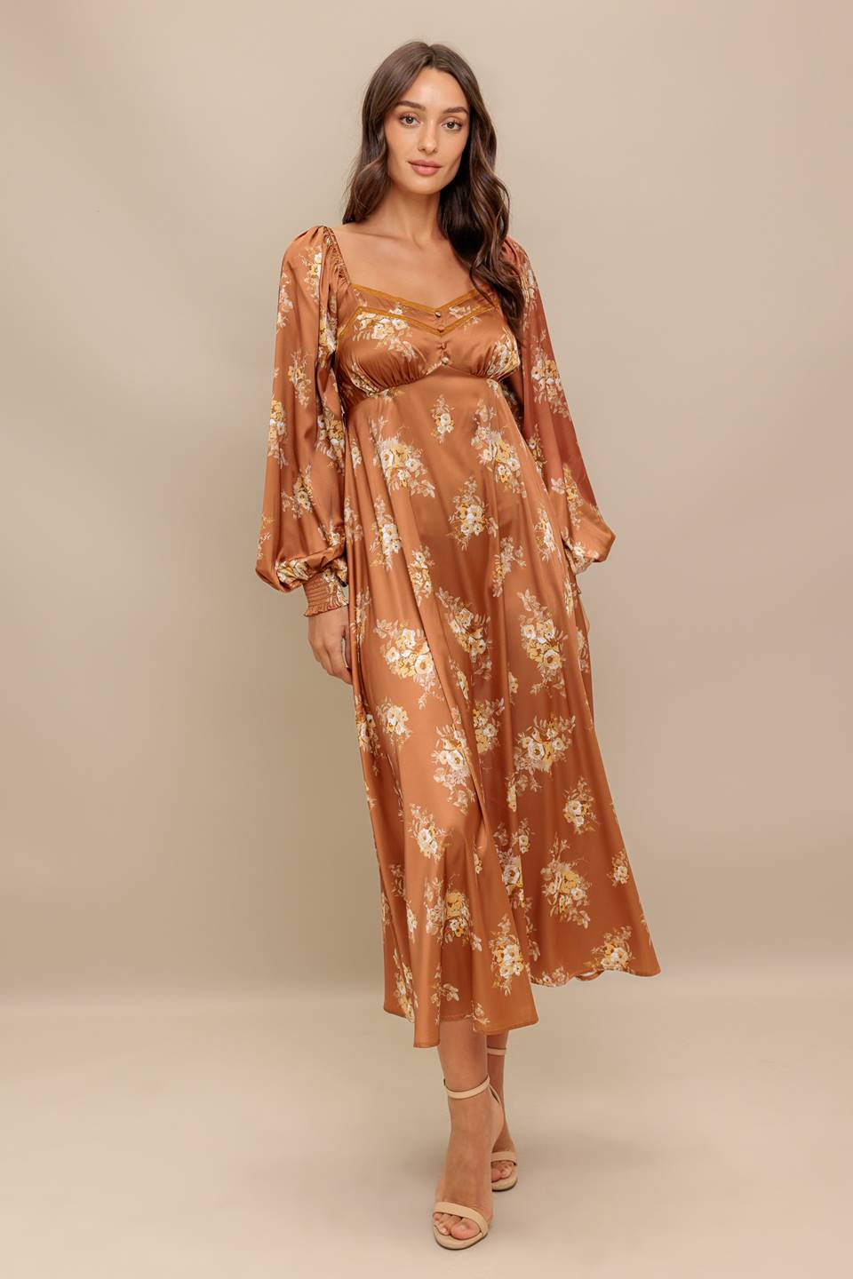 Woman wearing a long sleeve with smocked cuff bronze midi dress with floral print featuring sweetheart neckline, empire waistline, circle skirt and smocked back bodice | Flying Tomato