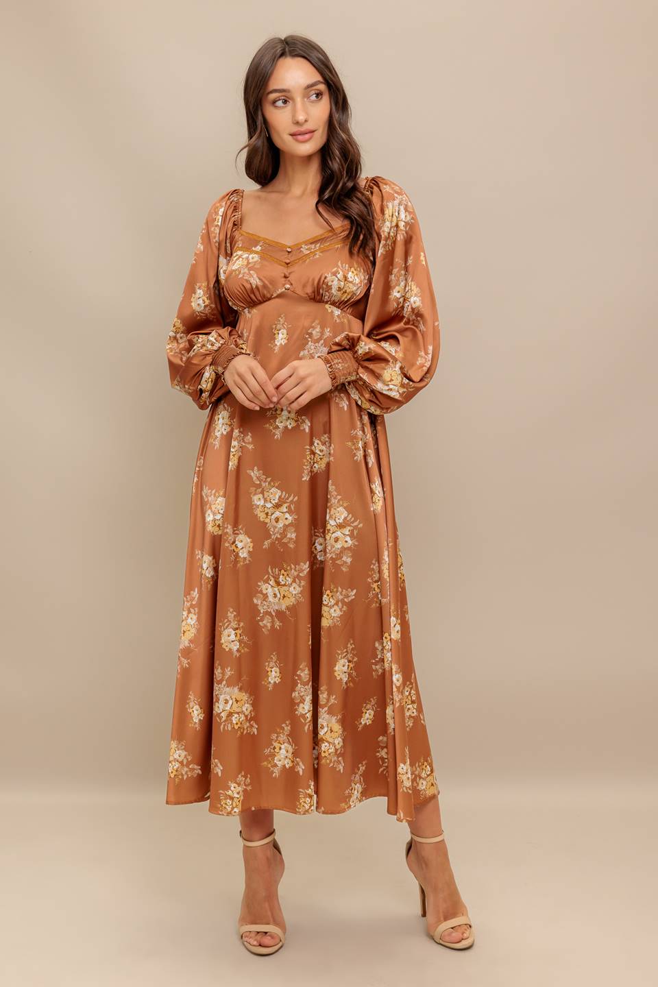 Woman wearing a long sleeve with smocked cuff bronze midi dress with floral print featuring sweetheart neckline, empire waistline, circle skirt and smocked back bodice | Flying Tomato