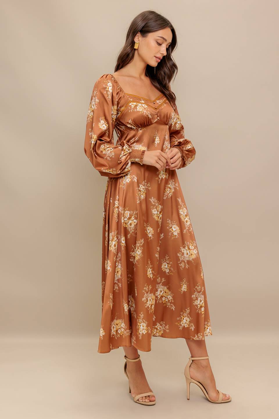 Woman wearing a long sleeve with smocked cuff bronze midi dress with floral print featuring sweetheart neckline, empire waistline, circle skirt and smocked back bodice | Flying Tomato