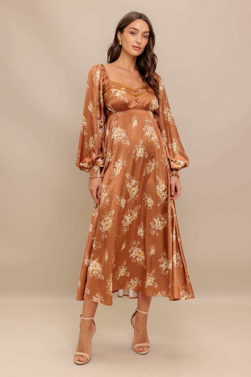 Woman wearing a long sleeve with smocked cuff bronze midi dress with floral print featuring sweetheart neckline, empire waistline, circle skirt and smocked back bodice | Flying Tomato