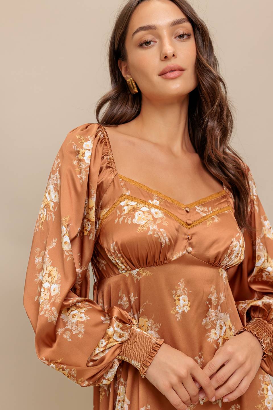 Woman wearing a long sleeve with smocked cuff bronze midi dress with floral print featuring sweetheart neckline, empire waistline, circle skirt and smocked back bodice | Flying Tomato