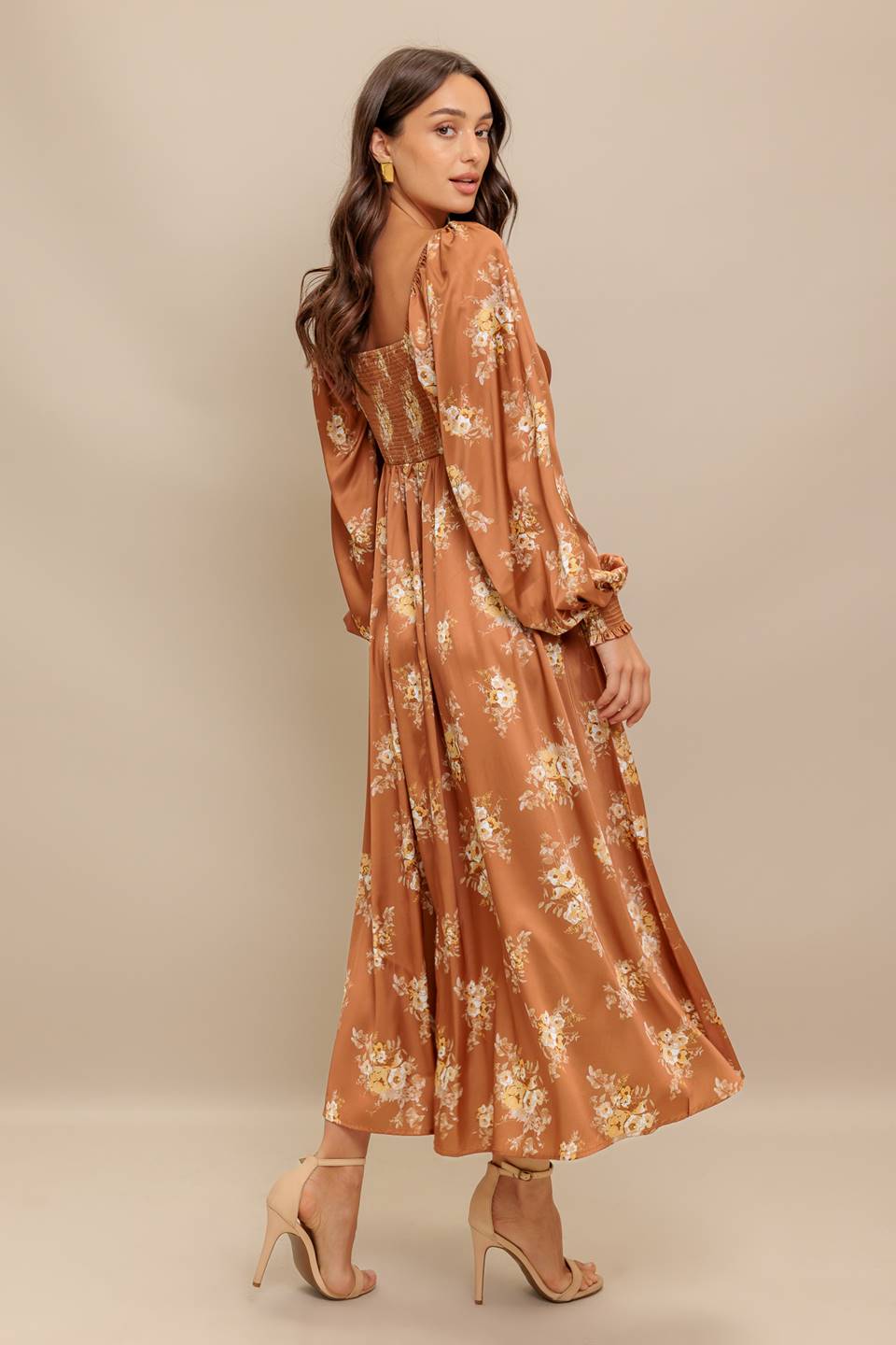 Woman wearing a long sleeve with smocked cuff bronze midi dress with floral print featuring sweetheart neckline, empire waistline, circle skirt and smocked back bodice | Flying Tomato