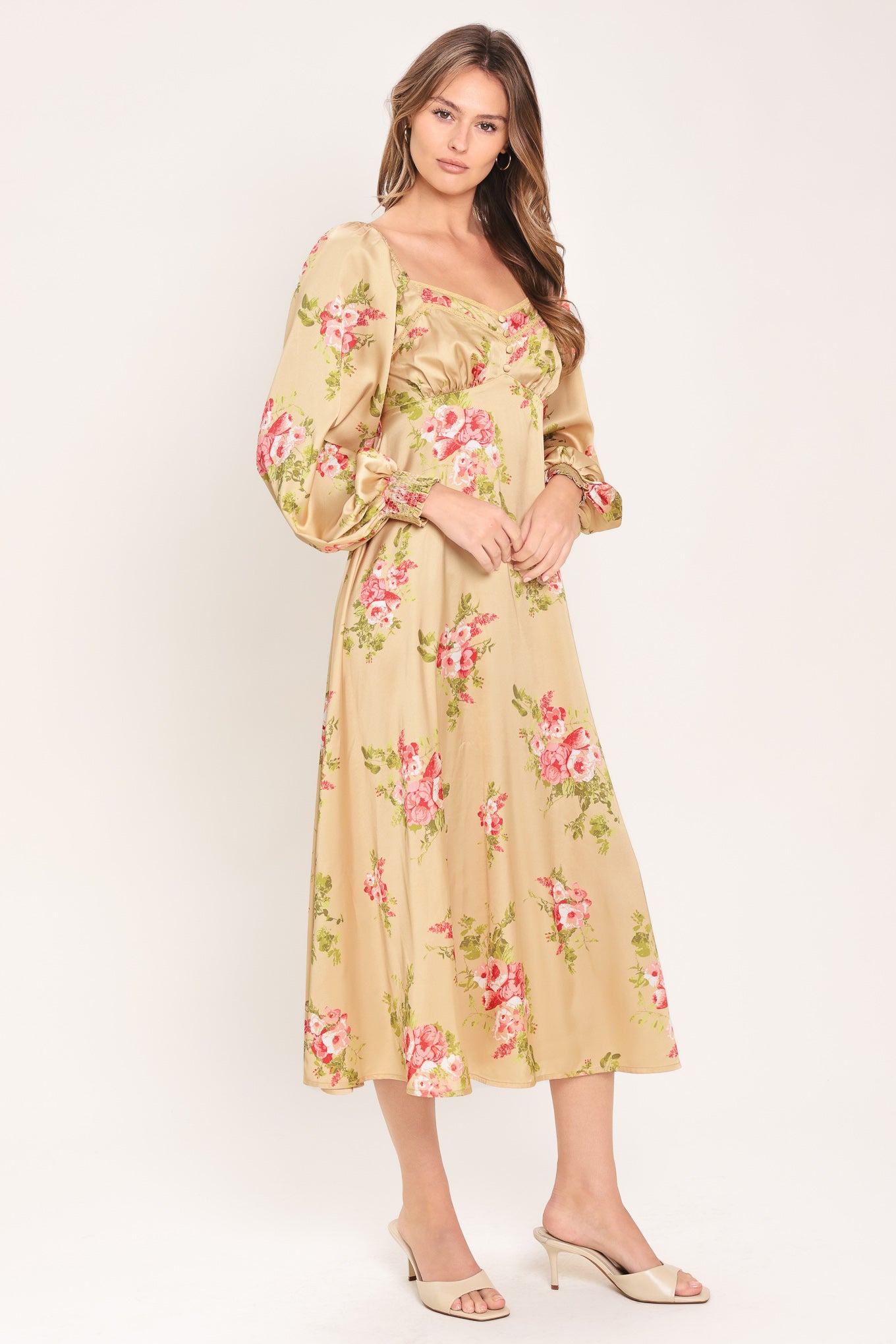 Woman wearing a long sleeve with smocked cuff champagne midi dress with floral print featuring sweetheart neckline, empire waistline, circle skirt and smocked back bodice | Flying Tomato