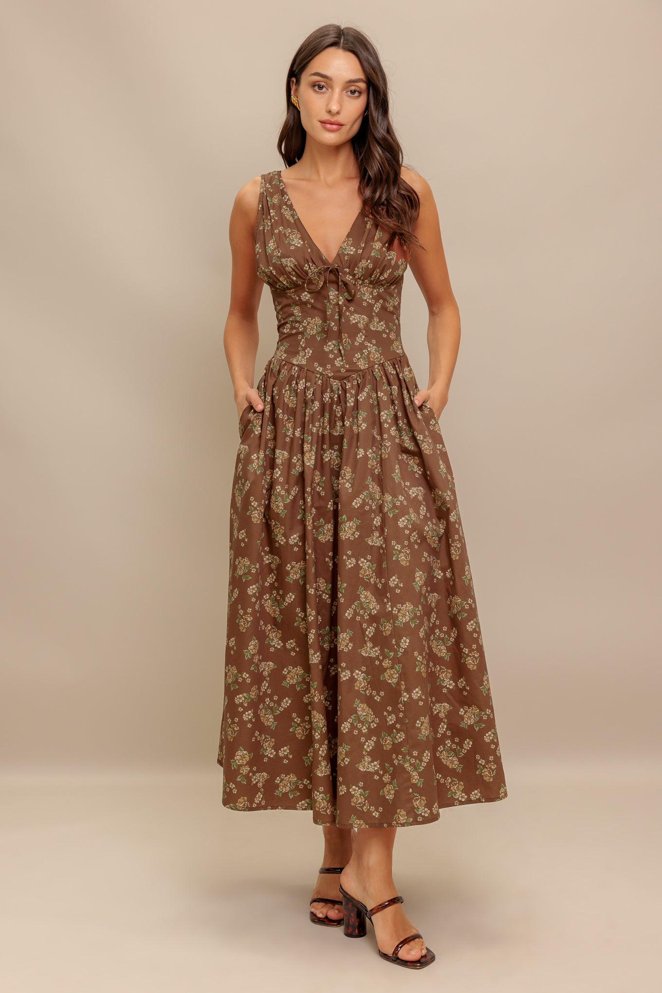 A printed woven midi dress featuring V neckline with bow tie, basque waistline, full skirt and back zipper closure