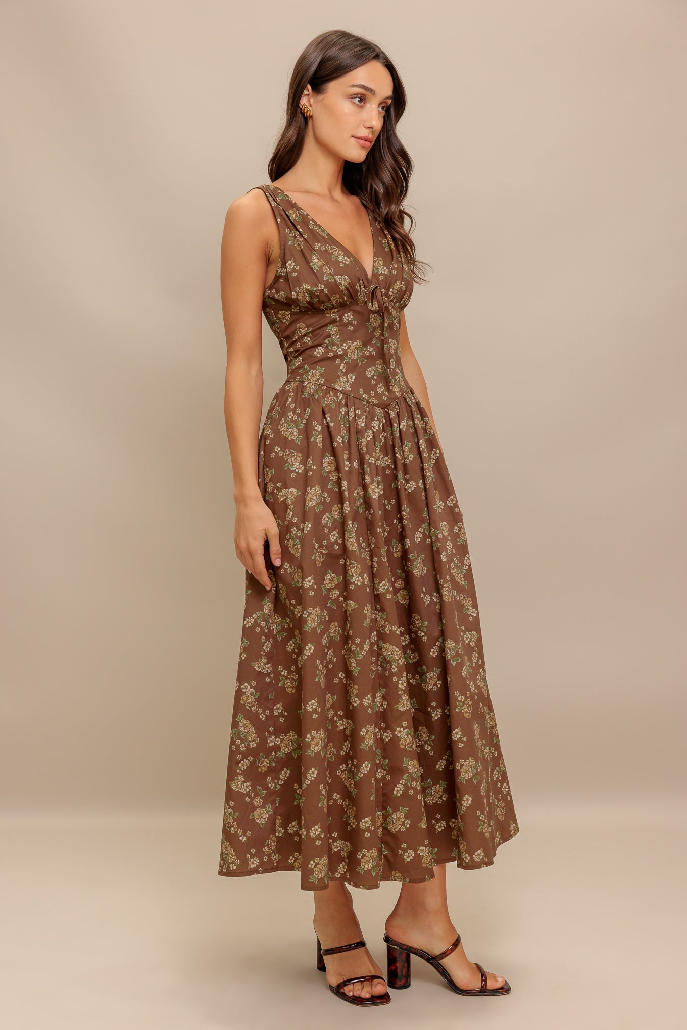 A printed woven midi dress featuring V neckline with bow tie, basque waistline, full skirt and back zipper closure