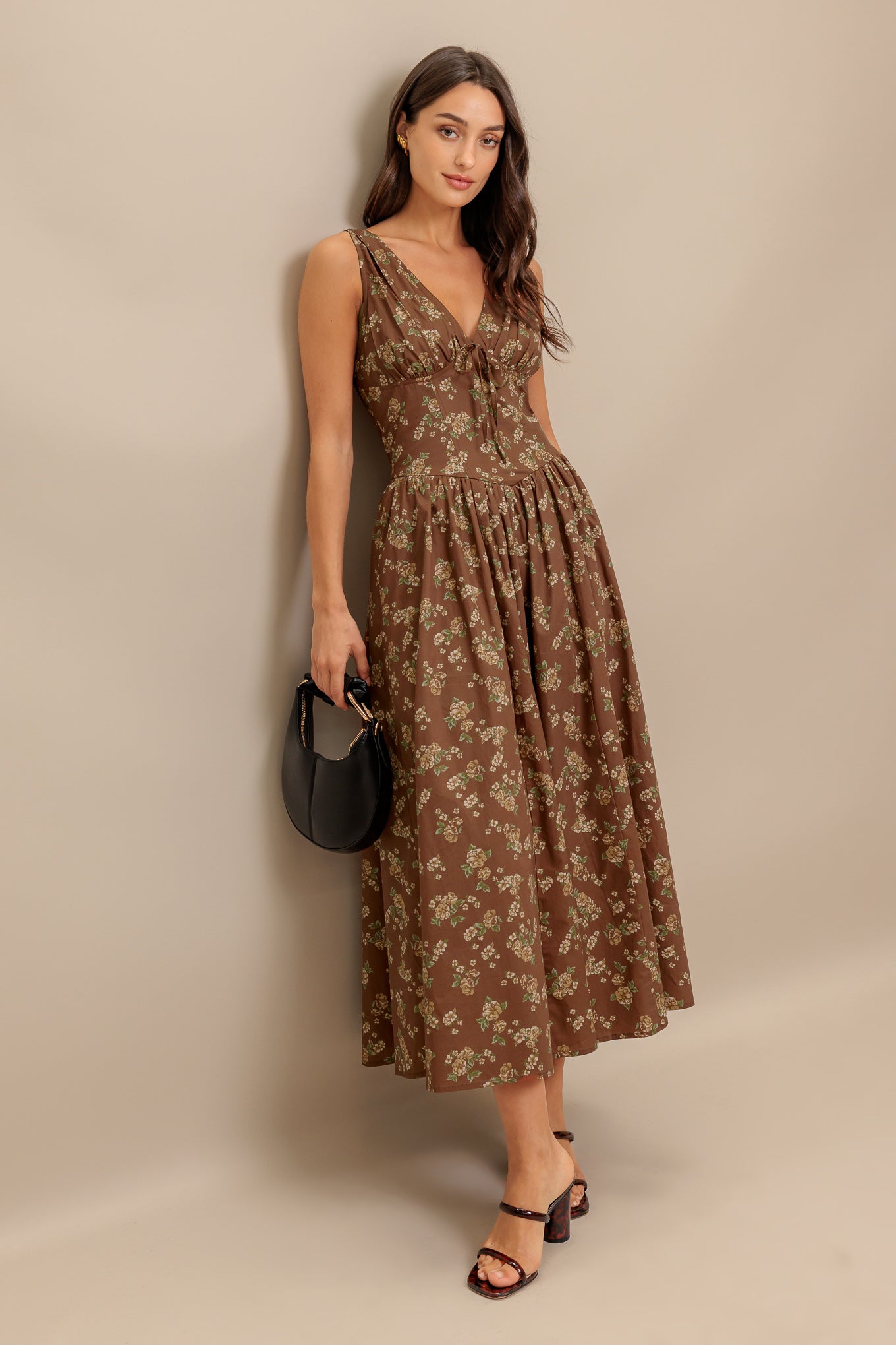 A printed woven midi dress featuring V neckline with bow tie, basque waistline, full skirt and back zipper closure