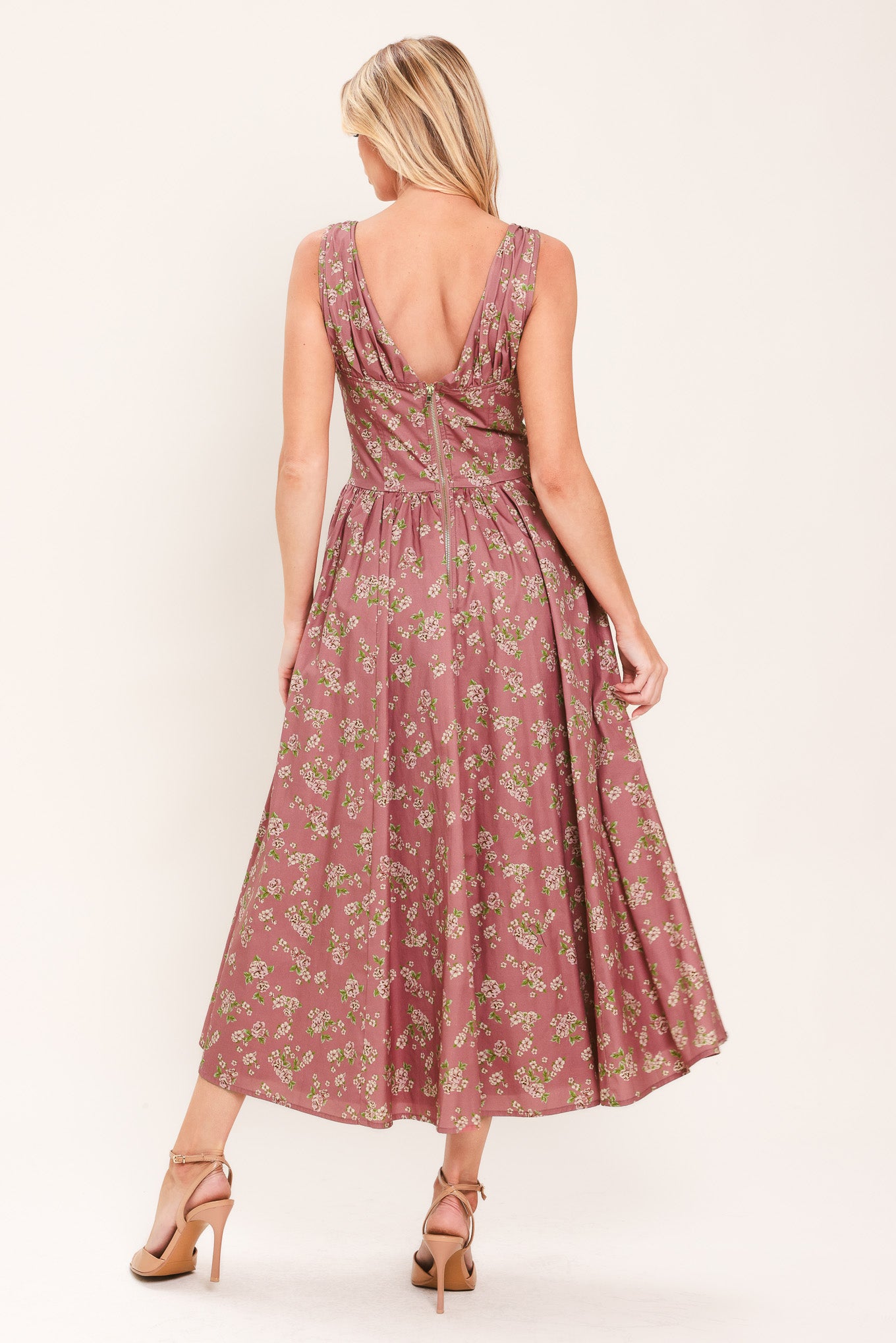Woman wearing a mauve pink midi dress with small floral print and a woven featuring V neckline with bow tie, basque waistline, full skirt and back zipper closure | Flying Tomato