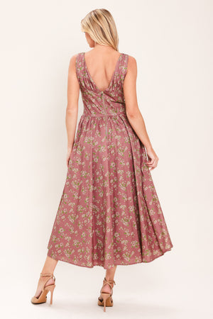 Woman wearing a mauve pink midi dress with small floral print and a woven featuring V neckline with bow tie, basque waistline, full skirt and back zipper closure | Flying Tomato