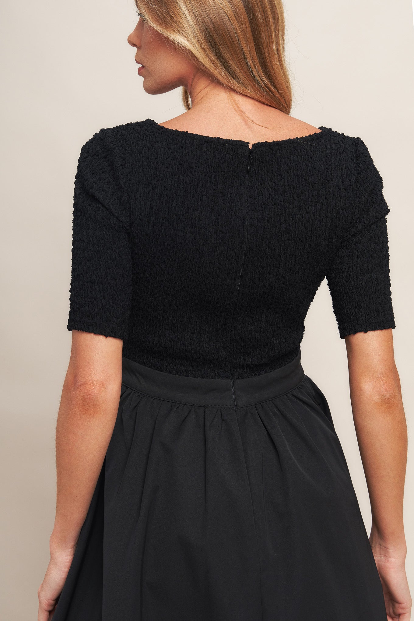 A solid woven midi dress featuring textured woven top with round neckline and short sleeve, full woven skirt and back zipper closure
