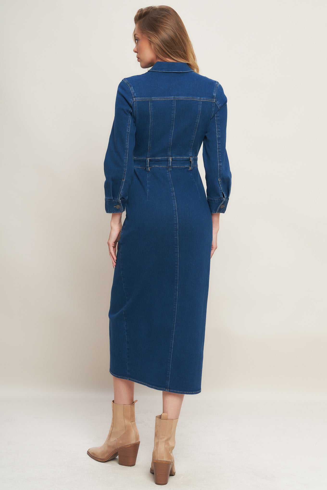 A washed denim midi dress featuring collar, hidden front zipper closure, long sleeve, front and side pockets with bottom front slit