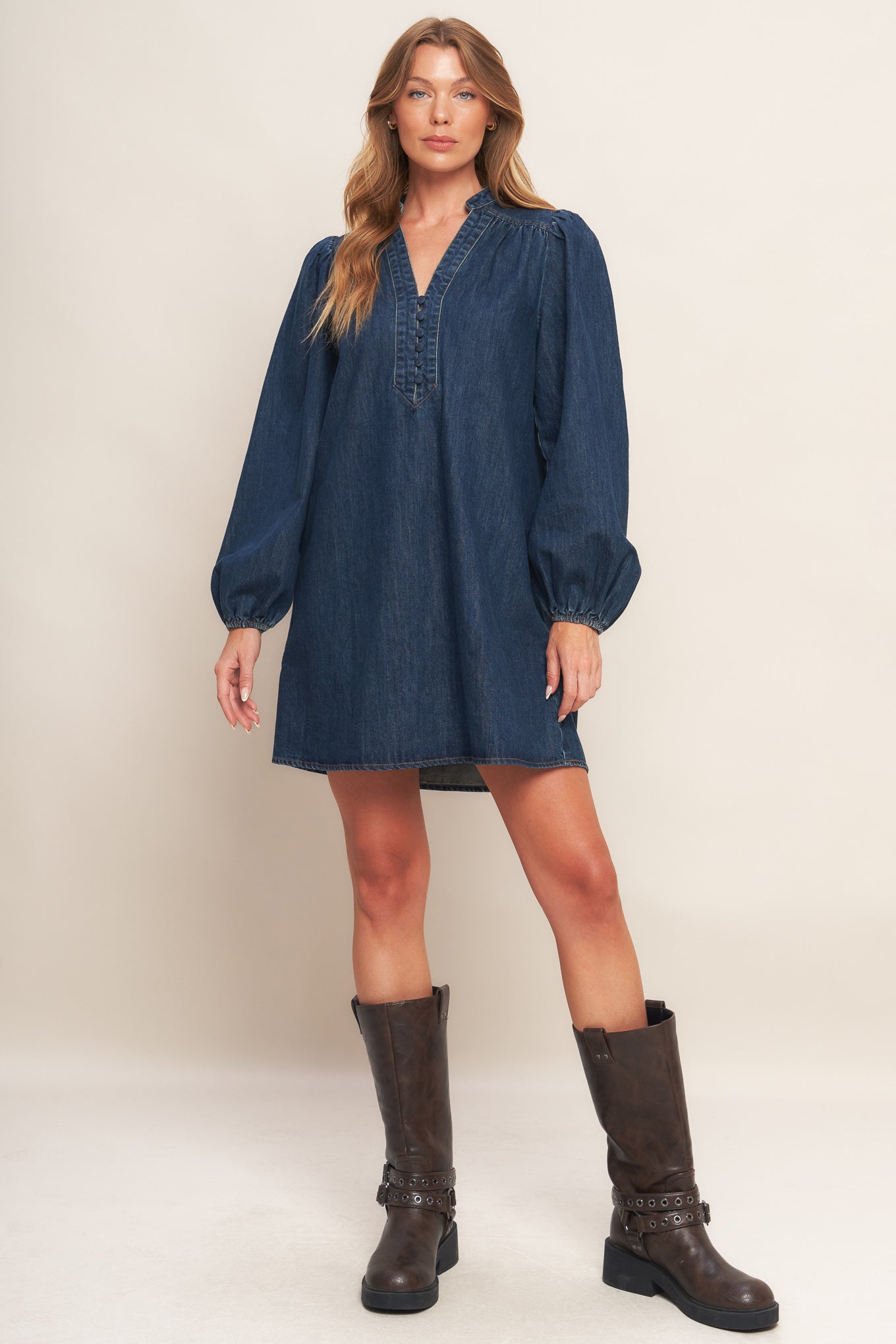 A washed denim mini dress featuring round neckline with V front, button down and long sleeve