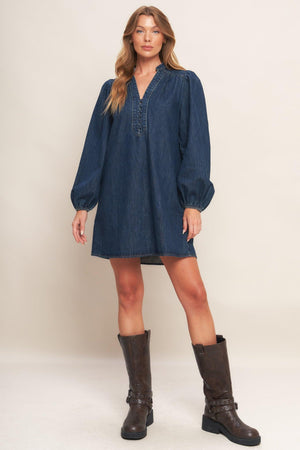 A washed denim mini dress featuring round neckline with V front, button down and long sleeve