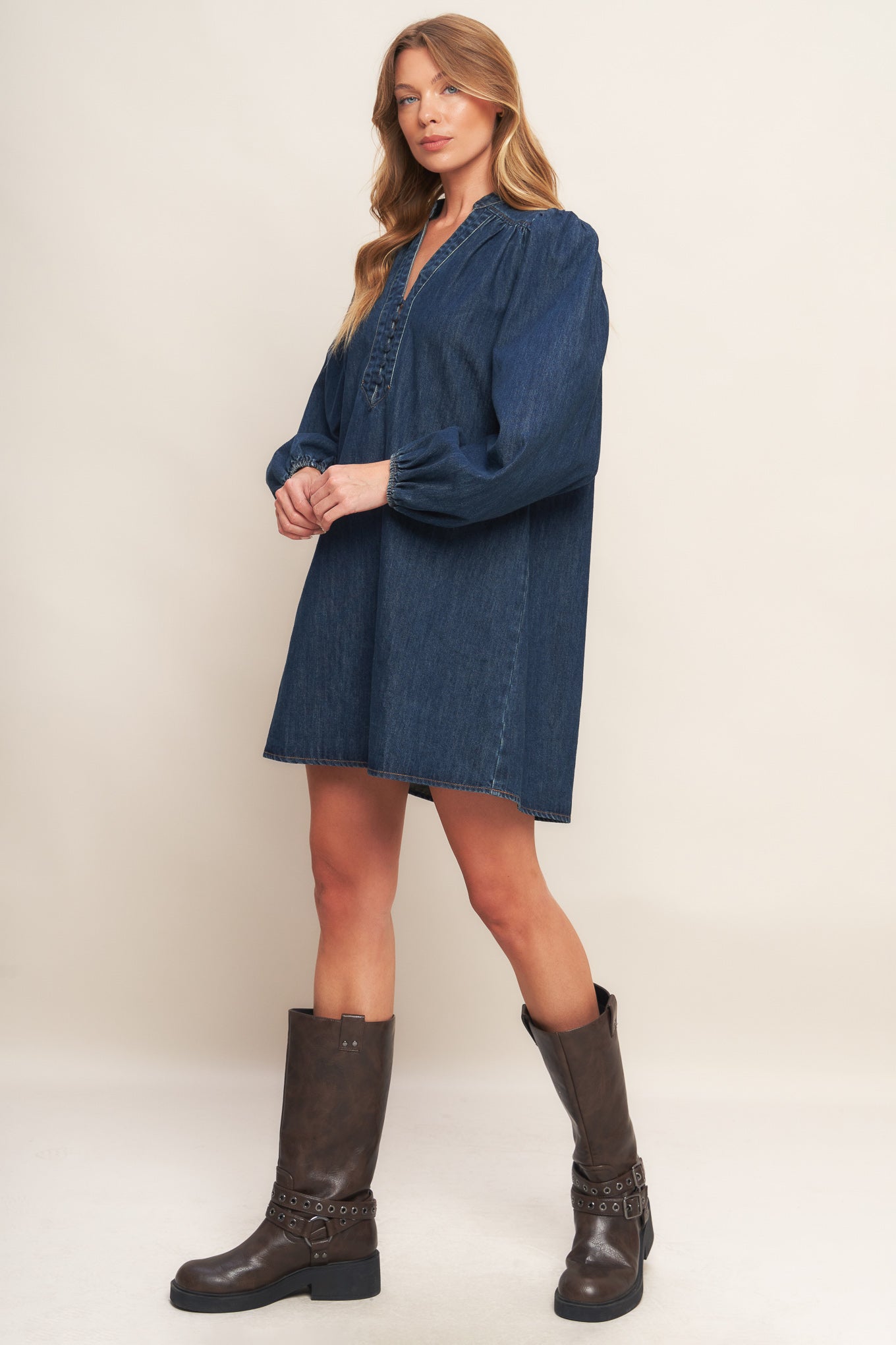 A washed denim mini dress featuring round neckline with V front, button down and long sleeve
