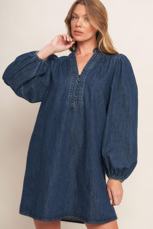 A washed denim mini dress featuring round neckline with V front, button down and long sleeve
