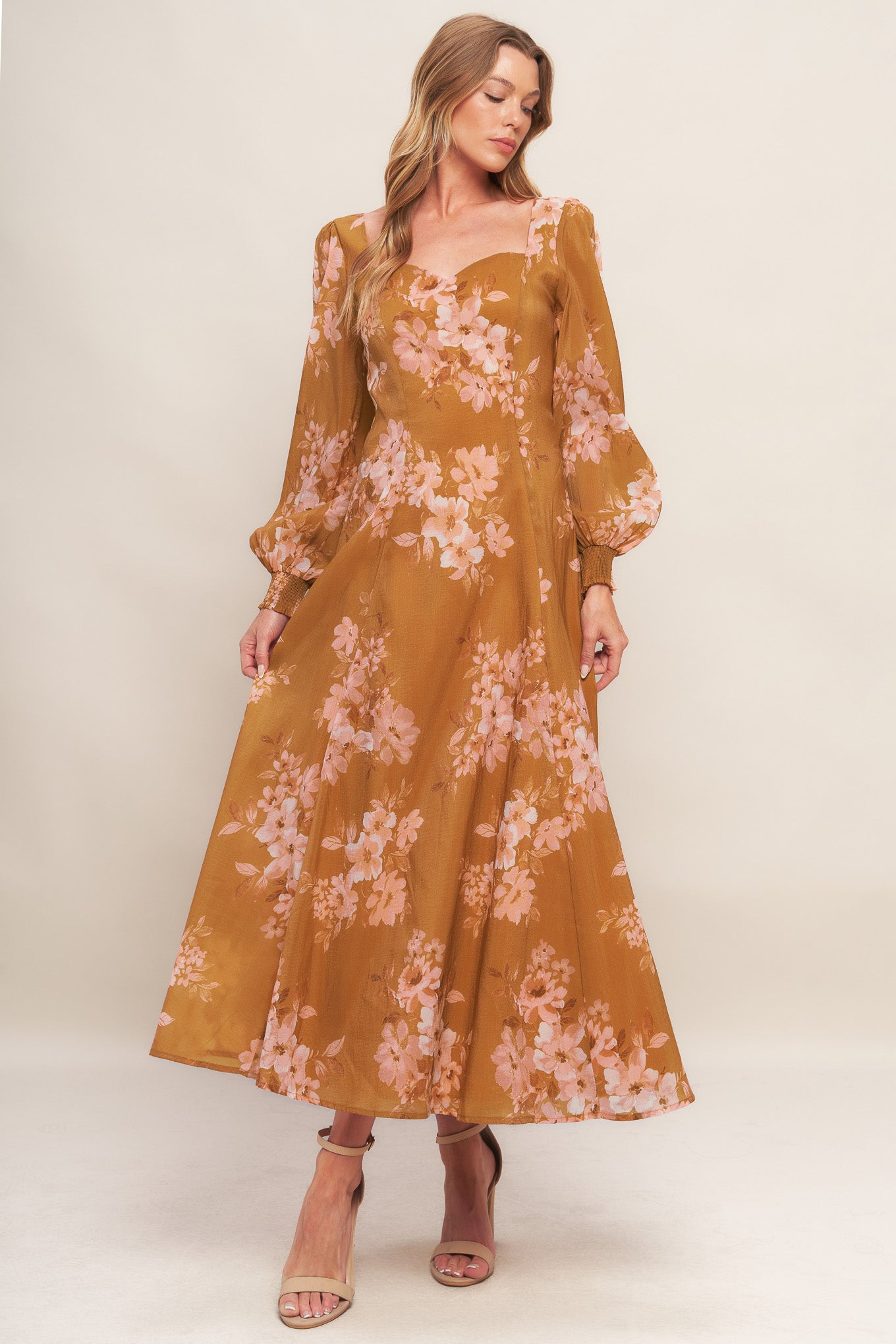 A printed woven ankle dress featuring sweetheart neckline, long sleeve with smocked cuff, circle skirt and back zipper closure