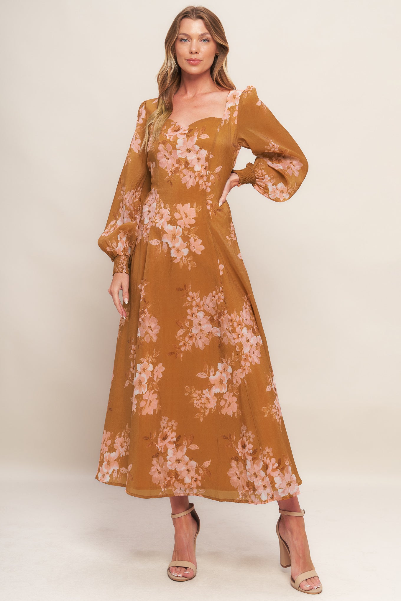 A printed woven ankle dress featuring sweetheart neckline, long sleeve with smocked cuff, circle skirt and back zipper closure