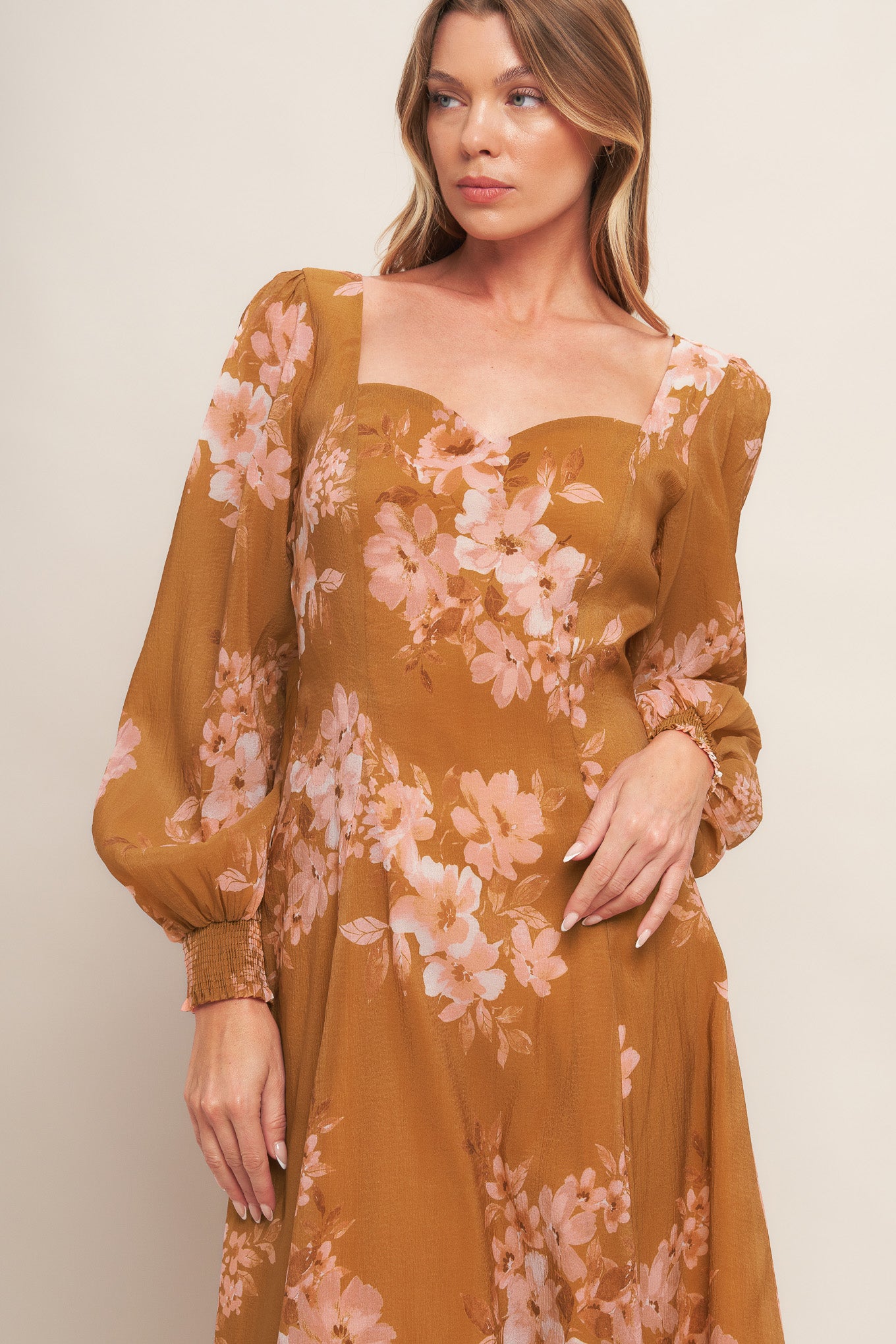A printed woven ankle dress featuring sweetheart neckline, long sleeve with smocked cuff, circle skirt and back zipper closure
