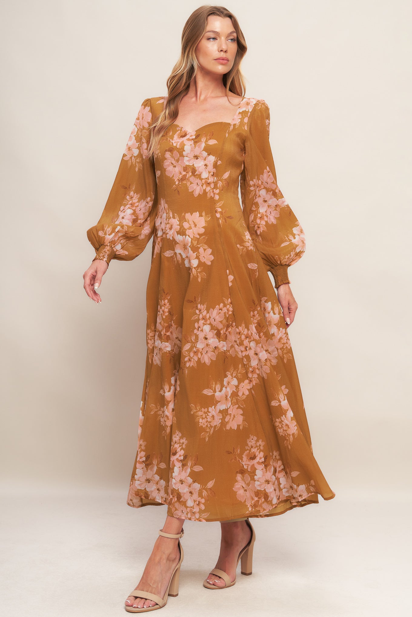 A printed woven ankle dress featuring sweetheart neckline, long sleeve with smocked cuff, circle skirt and back zipper closure