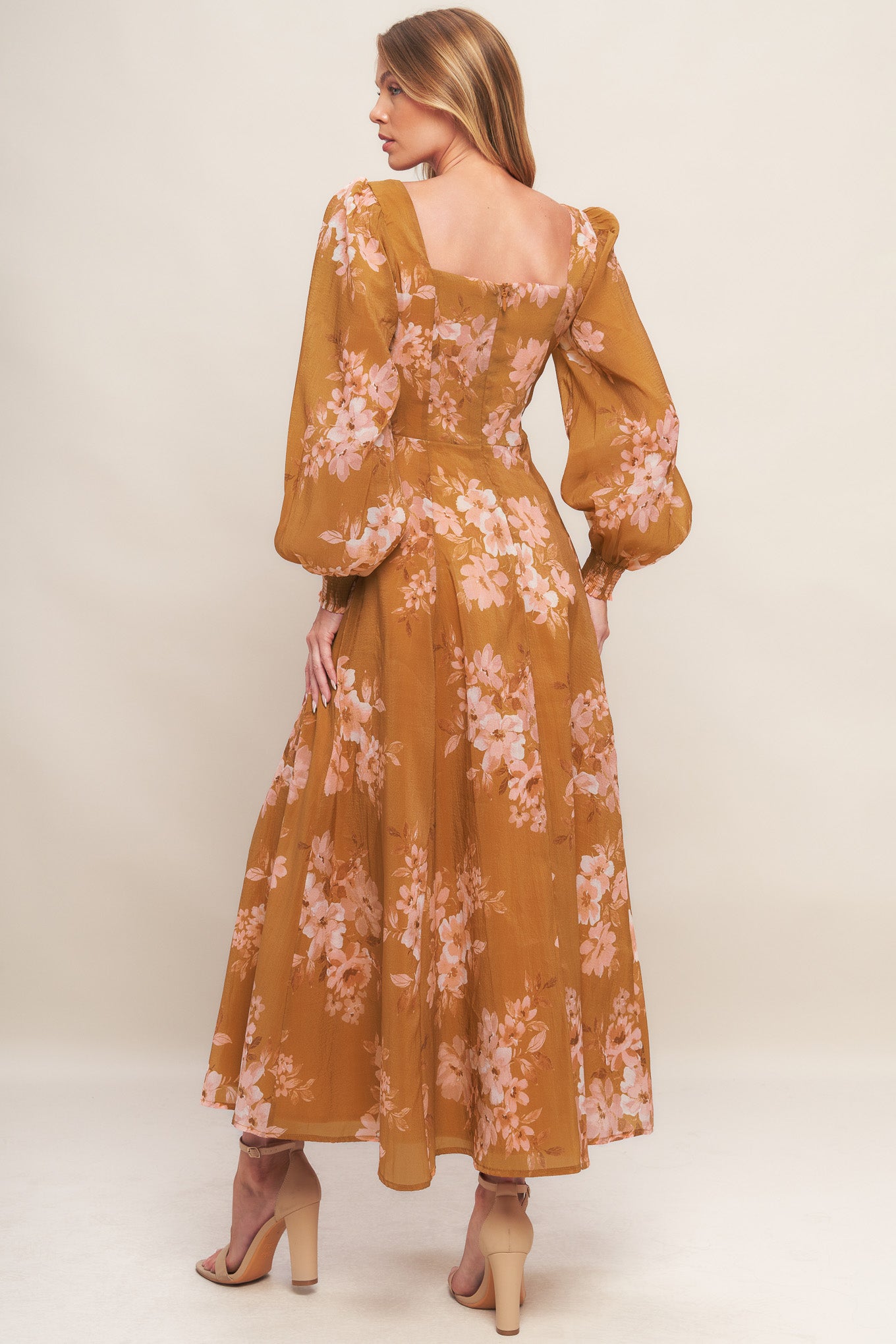 A printed woven ankle dress featuring sweetheart neckline, long sleeve with smocked cuff, circle skirt and back zipper closure