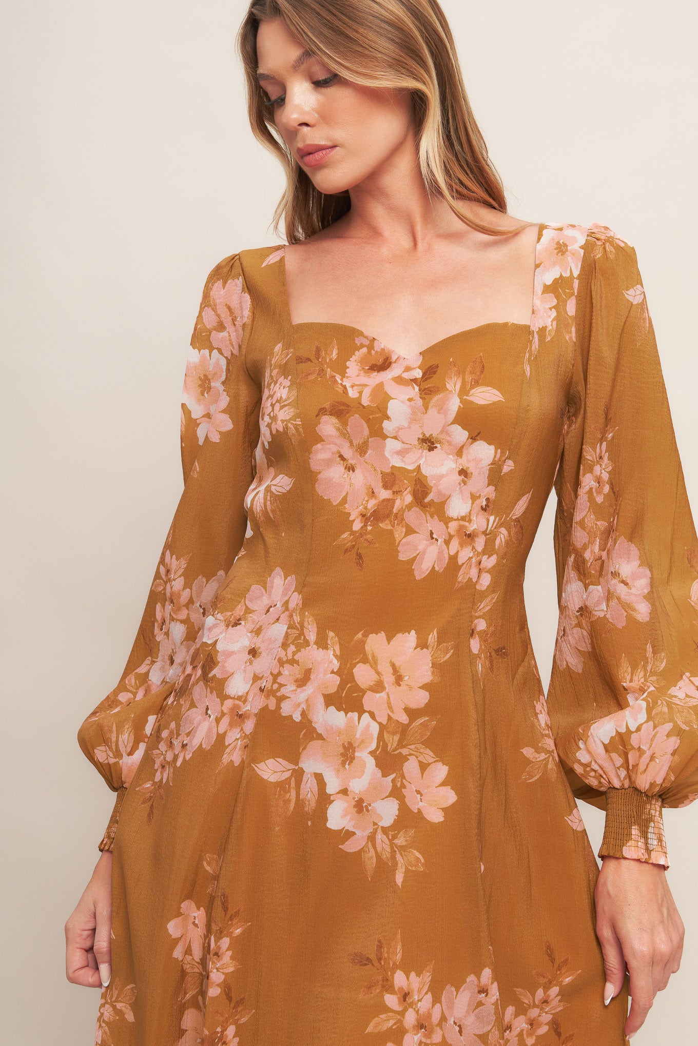 A printed woven ankle dress featuring sweetheart neckline, long sleeve with smocked cuff, circle skirt and back zipper closure
