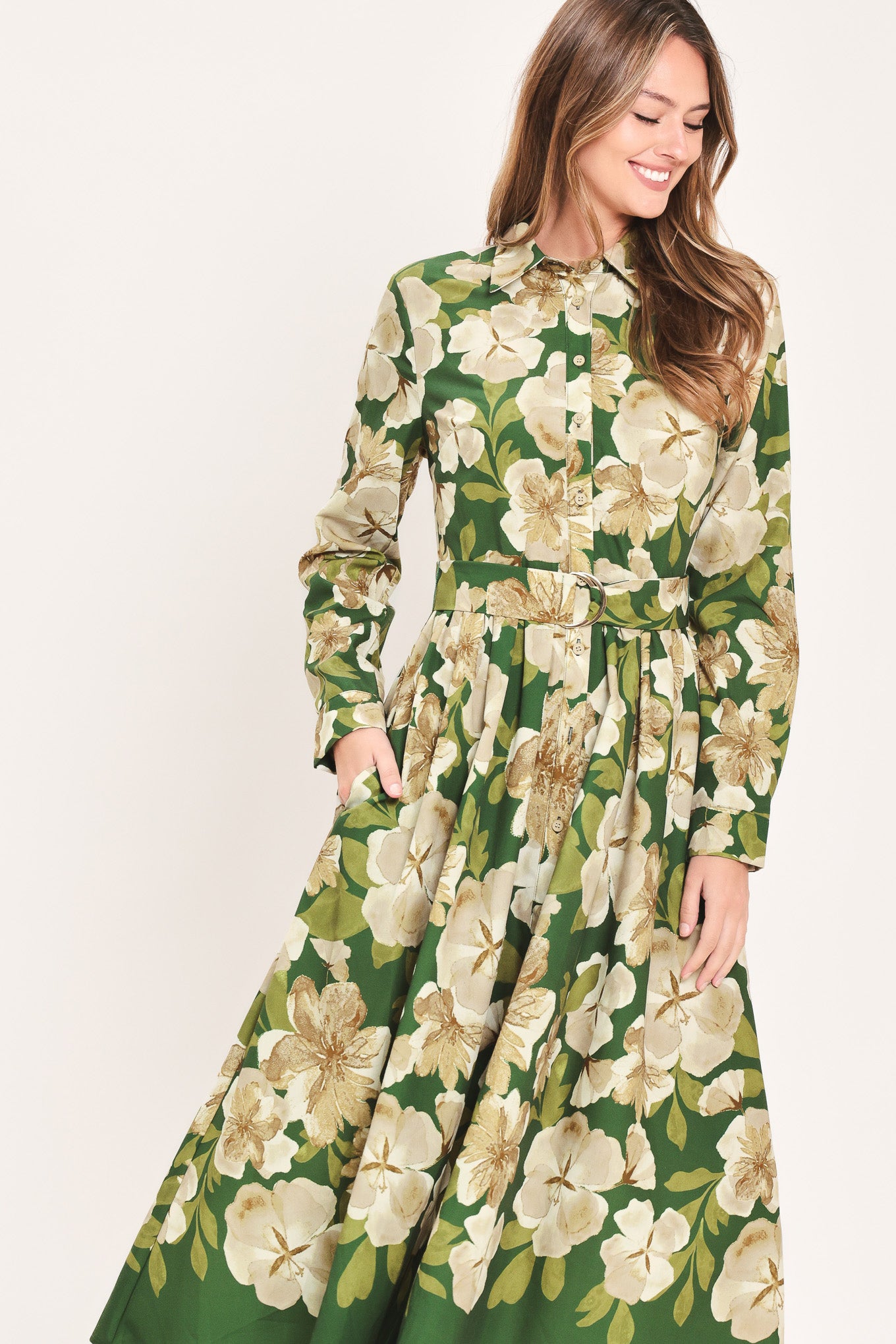 A woman wearing a long-sleeve midi dress with a green and cream floral print | Flying Tomato