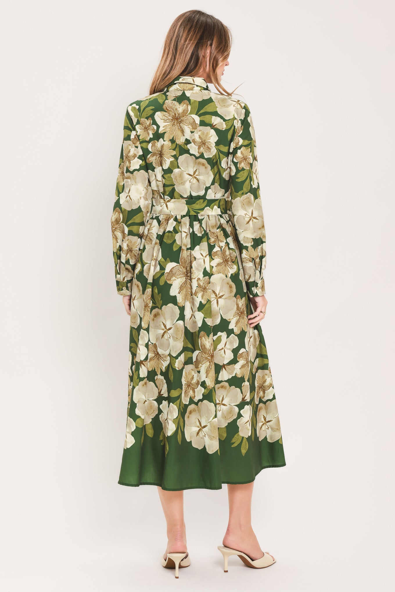 A woman wearing a long-sleeve midi dress with a green and cream floral print | Flying Tomato