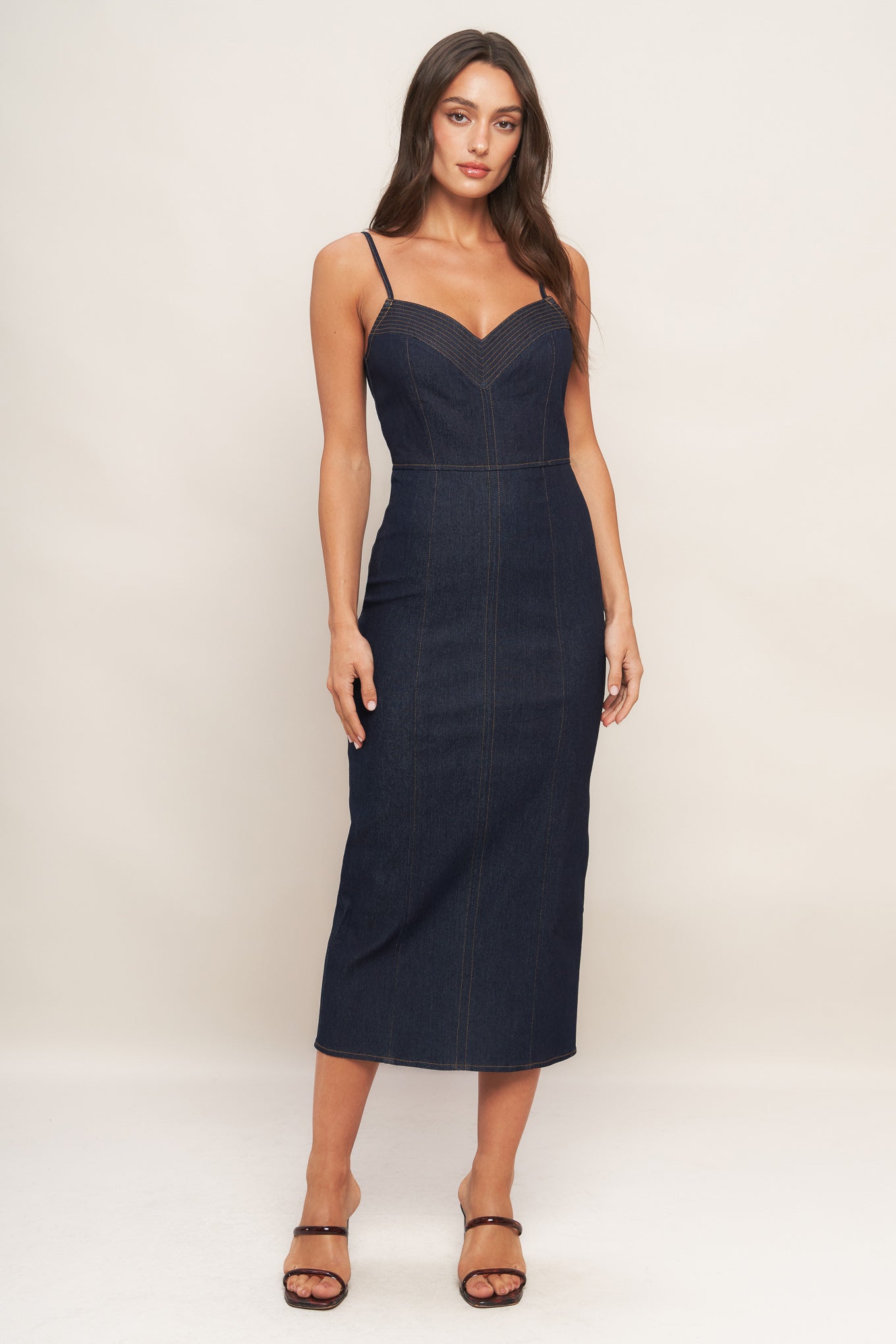 A denim midi dress featuring cami top with stitching detail, straps, pencil skirt and back zipper closure with slit