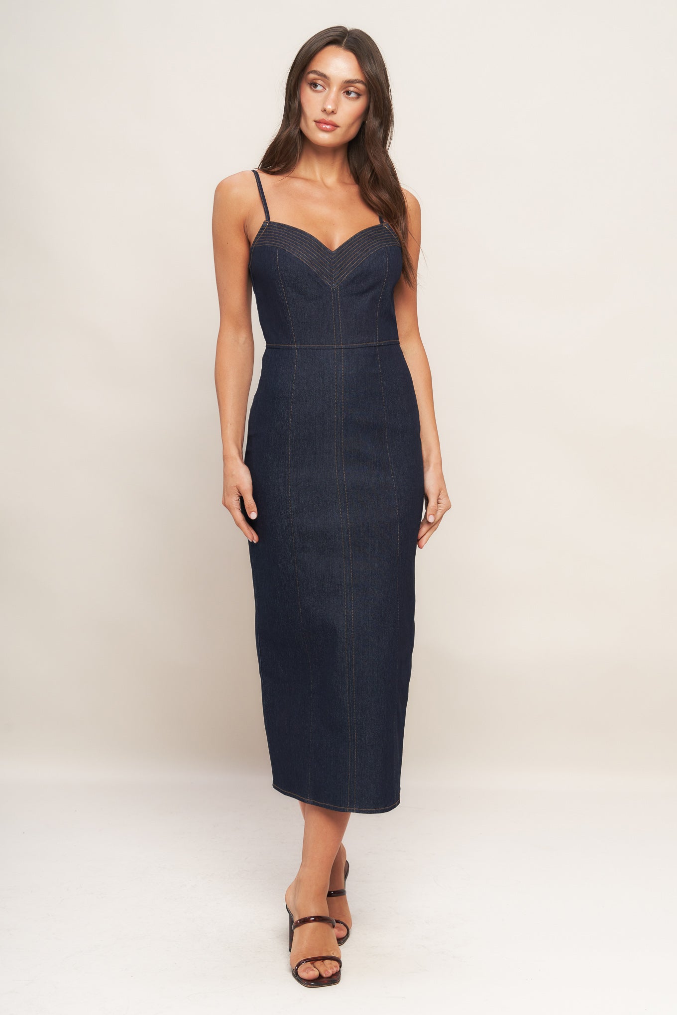 A denim midi dress featuring cami top with stitching detail, straps, pencil skirt and back zipper closure with slit