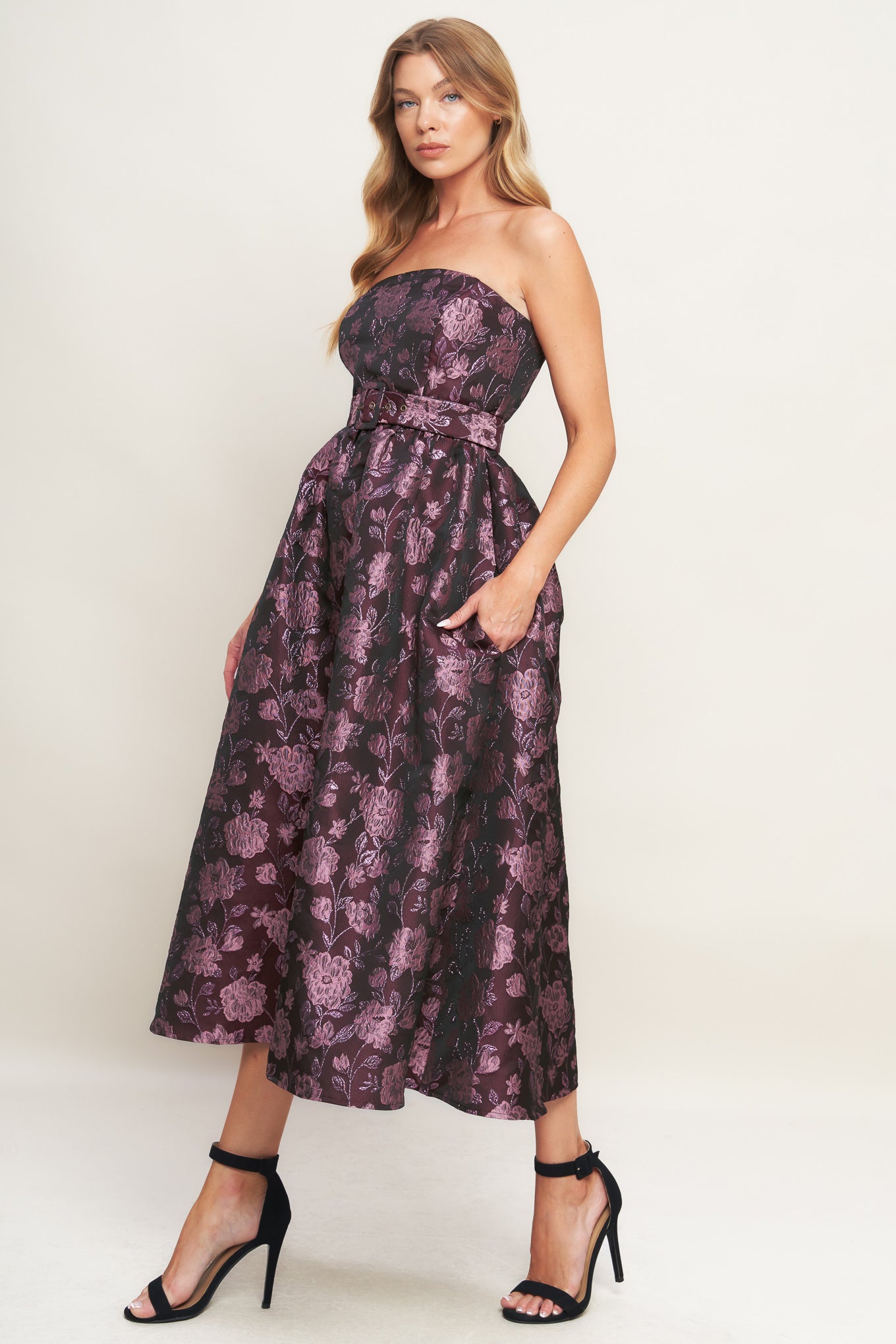 A jacquard woven midi dress featuring strapless neckline, self belt, full skirt and back zipper closure