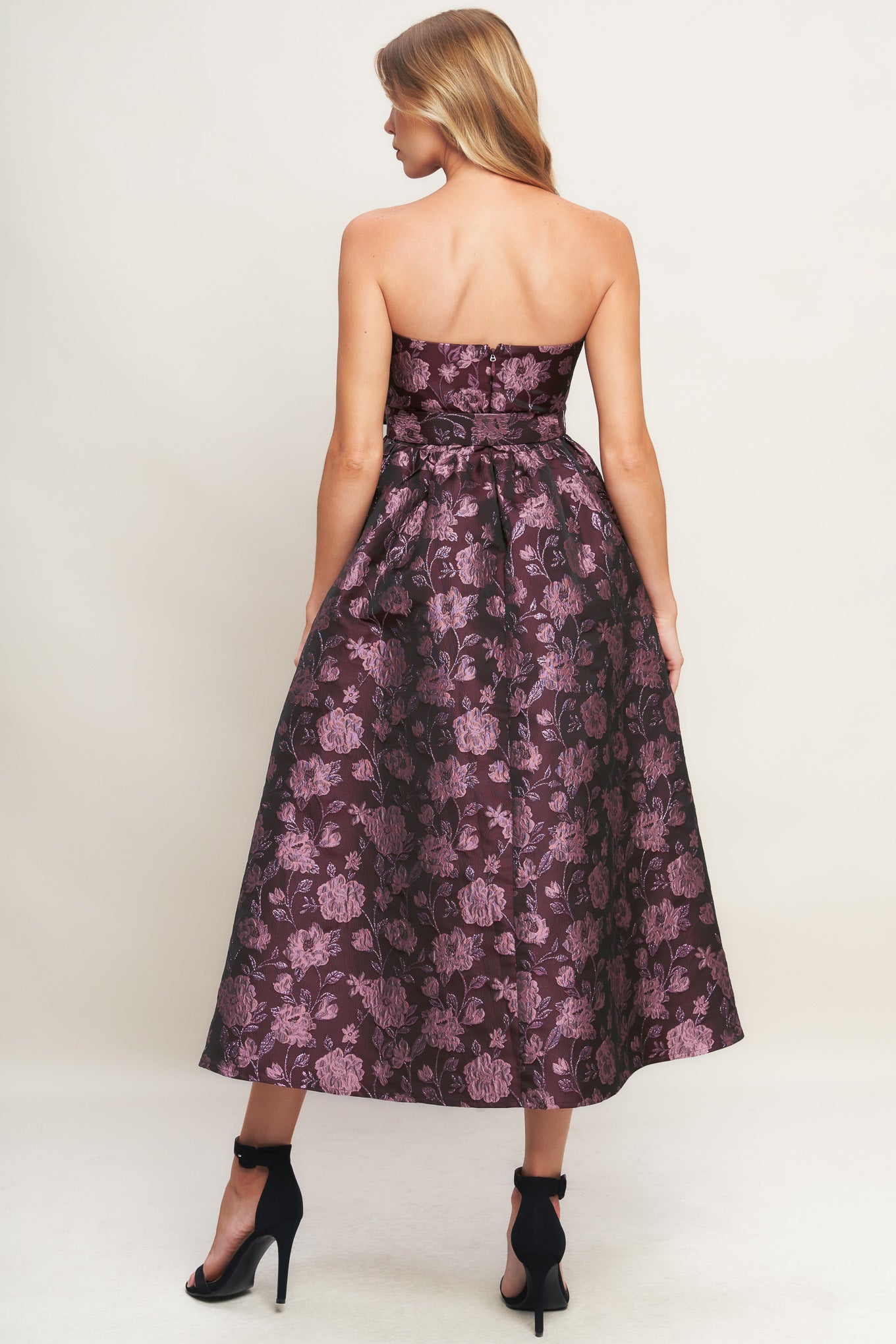 A jacquard woven midi dress featuring strapless neckline, self belt, full skirt and back zipper closure