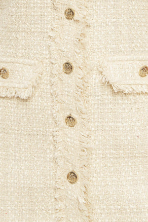 A tweed mini dress featuring frayed collar and placket, short sleeve and button down closure
