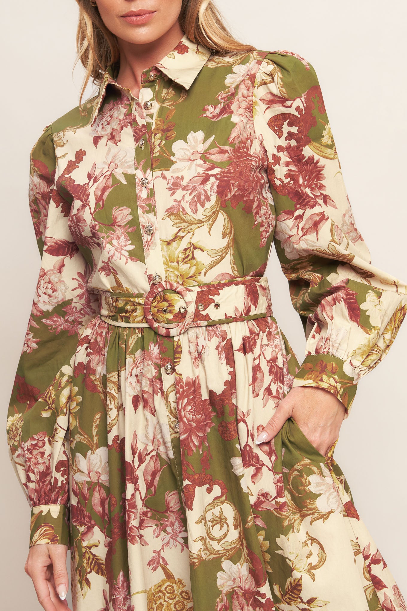 A printed woven midi dress featuring collar, long sleeve with cuff, front button down closure, self belt and full skirt