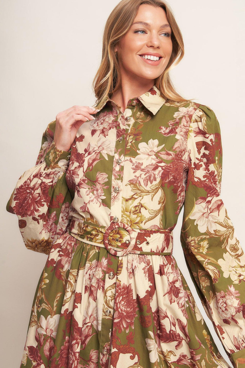 A printed woven midi dress featuring collar, long sleeve with cuff, front button down closure, self belt and full skirt