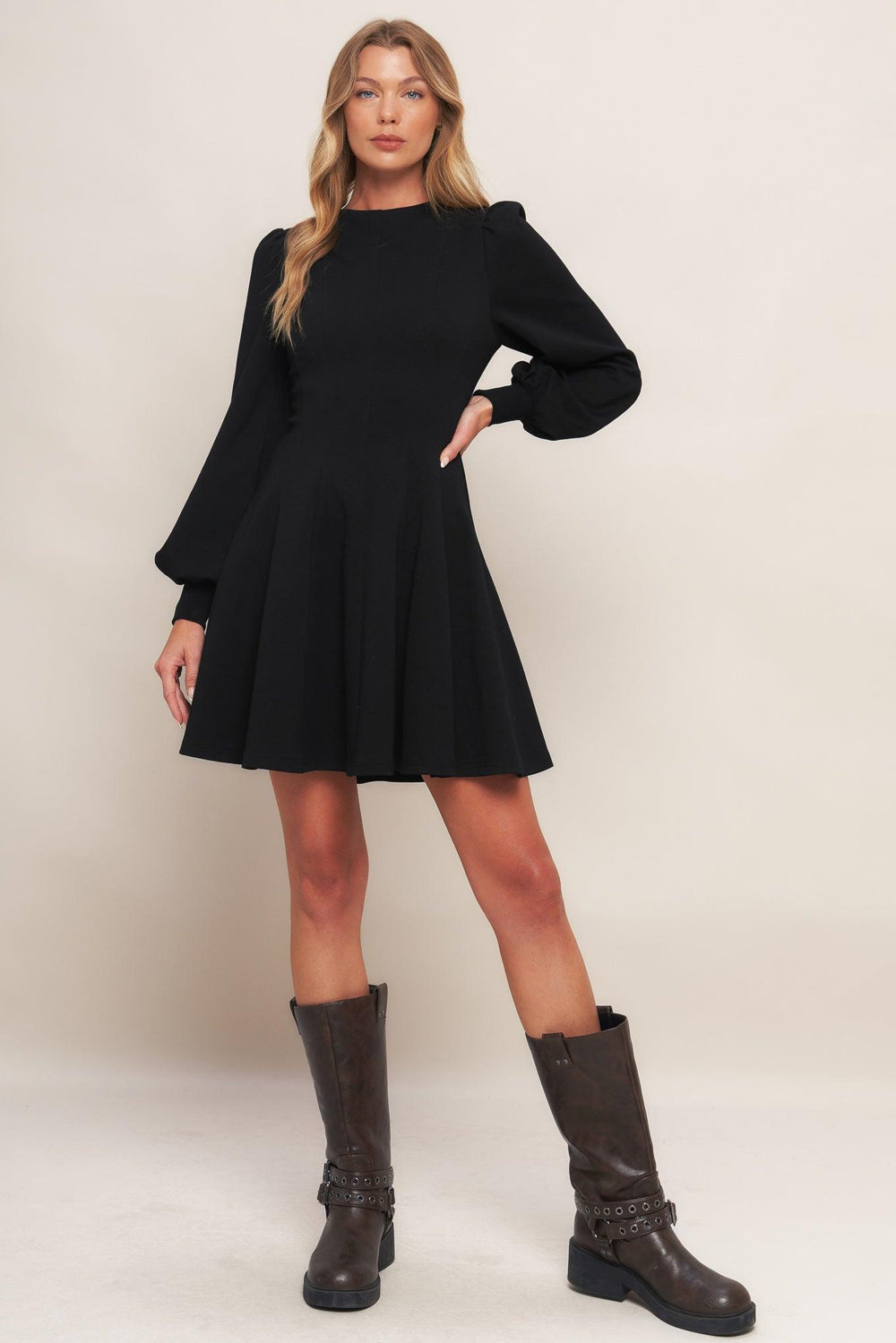 A solid heavy knit mini dress featuring round neckline, long sleeve with cuff, circle skirt and back zipper closure