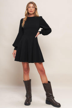 A solid heavy knit mini dress featuring round neckline, long sleeve with cuff, circle skirt and back zipper closure