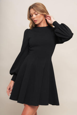 A solid heavy knit mini dress featuring round neckline, long sleeve with cuff, circle skirt and back zipper closure