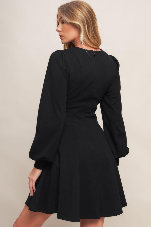 A solid heavy knit mini dress featuring round neckline, long sleeve with cuff, circle skirt and back zipper closure