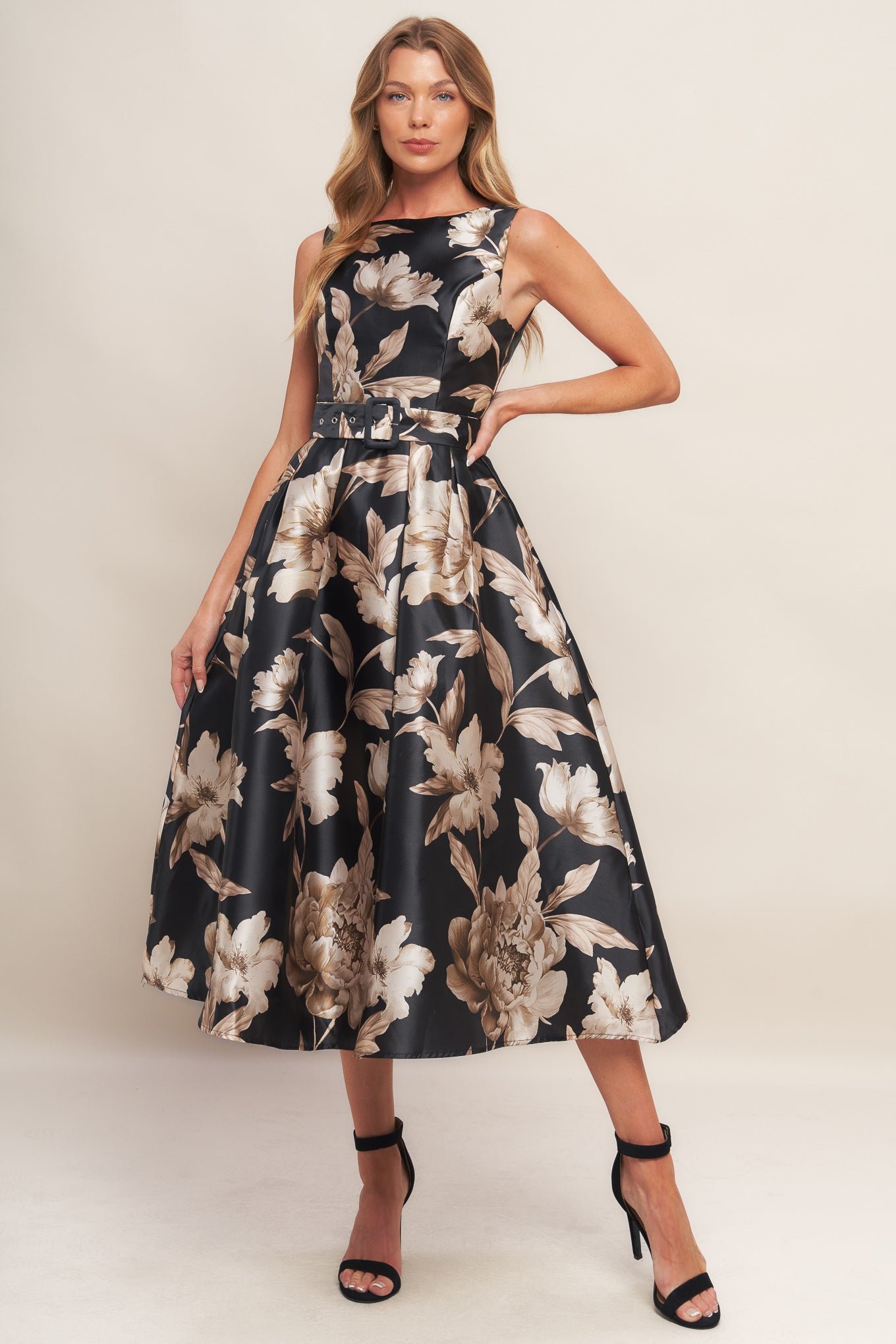 A printed woven midi dress featuring wide neckline, sleeveless, self belt, full skirt and back zipper closure