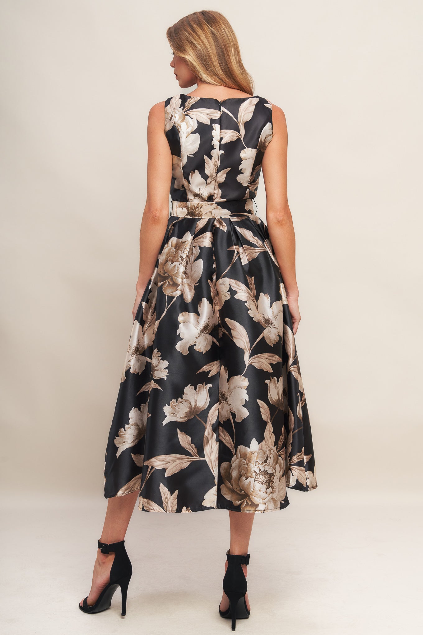 A printed woven midi dress featuring wide neckline, sleeveless, self belt, full skirt and back zipper closure