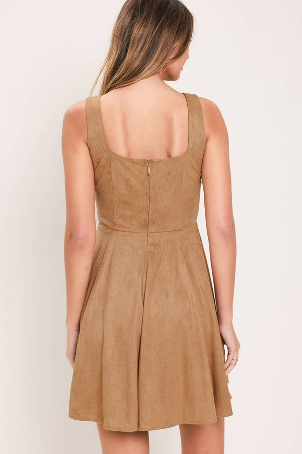 A woman modeling a sleeveless camel suede dress with a square neckline, front tie detail, and a flared skirt | Flying Tomato