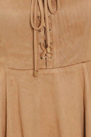 A woman modeling a sleeveless camel suede dress with a square neckline, front tie detail, and a flared skirt | Flying Tomato