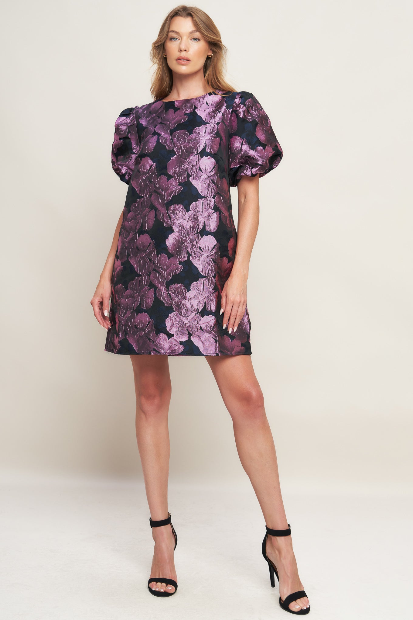 A textured woven mini dress featuring round neckline, short puff sleeve and back neck button closure
